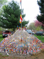 Image of sand hill at Lao new year. Des Moines Lao community members pay homage by creating and decorating this sand mountain with flags.
